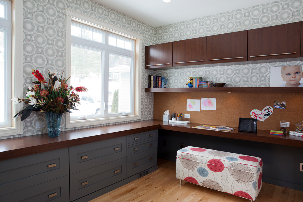 Стильный дизайн: кабинет с серыми стенами, паркетным полом среднего тона и встроенным рабочим столом - последний тренд