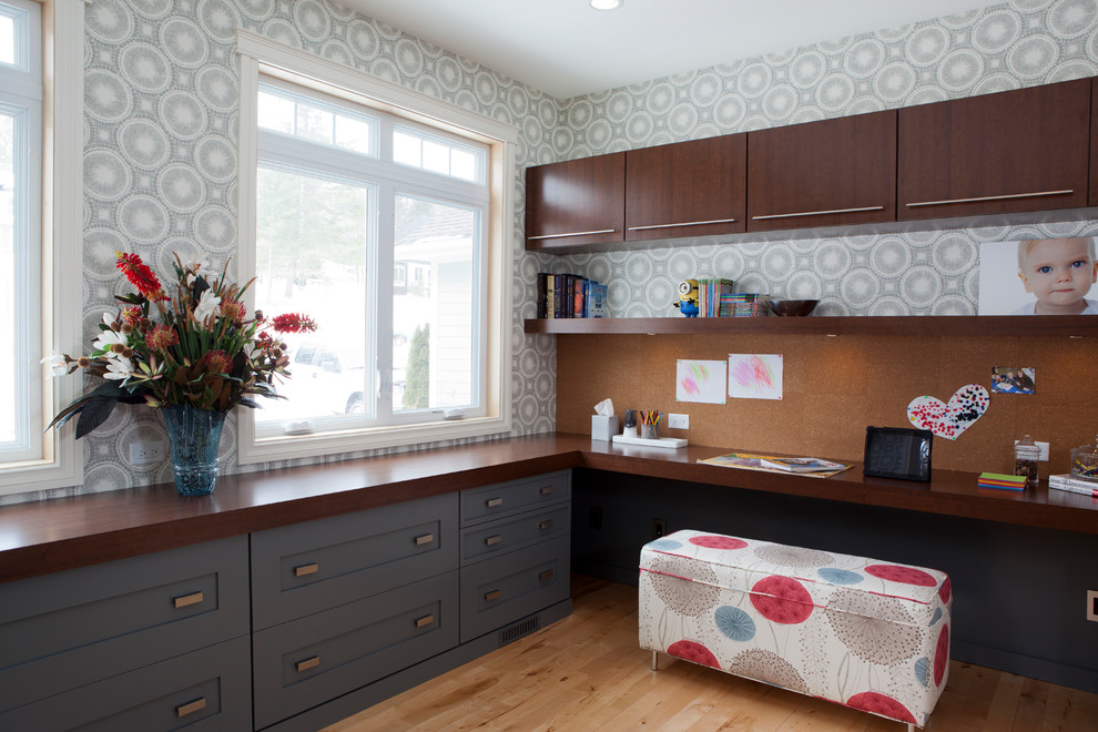 Home office - built-in desk medium tone wood floor home office idea in Other with gray walls