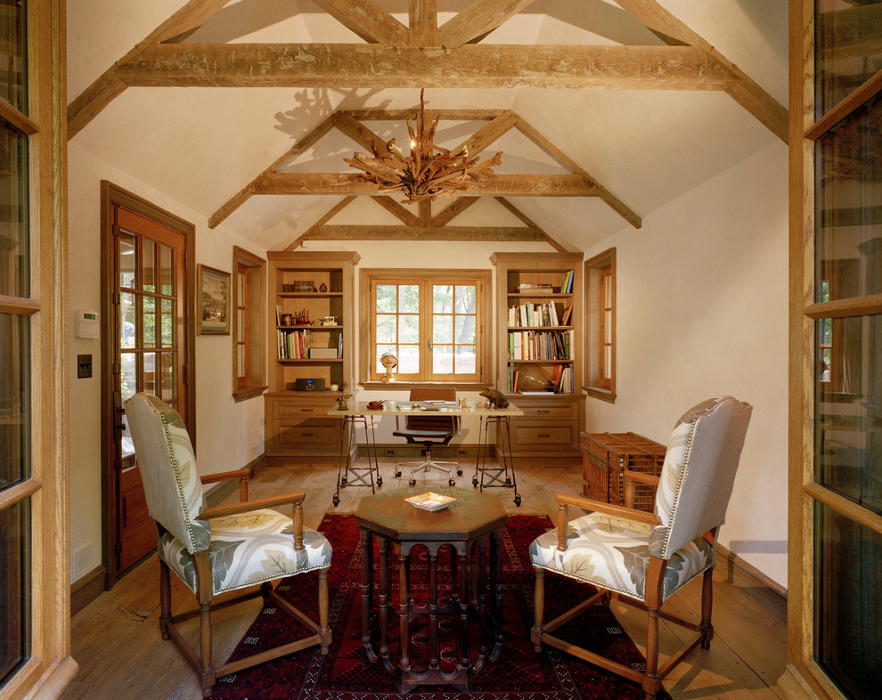 Ejemplo de despacho de estilo de casa de campo sin chimenea con paredes beige, suelo de madera en tonos medios y escritorio independiente