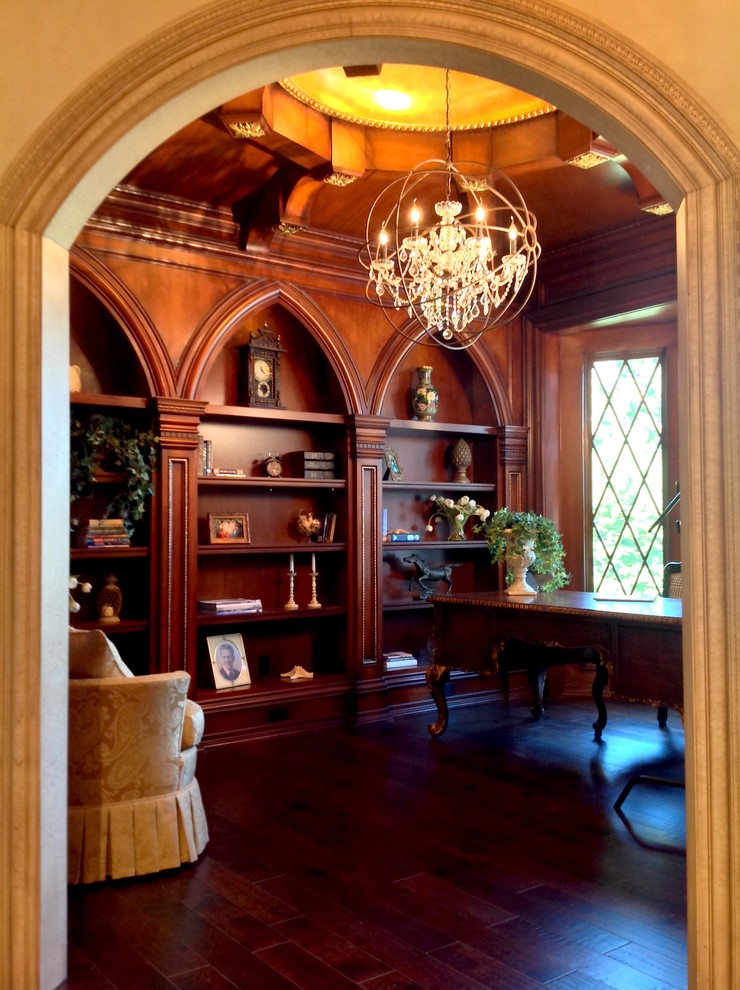 Geräumiges Klassisches Lesezimmer mit brauner Wandfarbe, dunklem Holzboden, freistehendem Schreibtisch und braunem Boden in Cincinnati