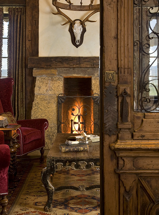 他の地域にあるラグジュアリーな広いラスティックスタイルのおしゃれなホームオフィス・書斎 (ライブラリー、標準型暖炉、石材の暖炉まわり) の写真