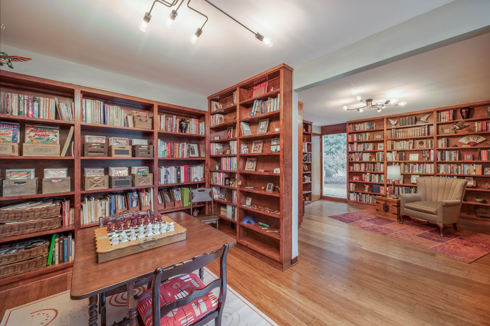 Aménagement d'un très grand bureau rétro avec une bibliothèque ou un coin lecture, un mur blanc, un sol en bois brun et un sol marron.