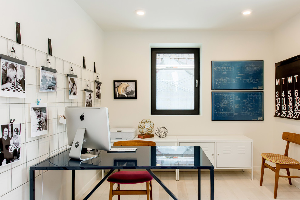 Mittelgroßes Industrial Arbeitszimmer mit weißer Wandfarbe, hellem Holzboden, freistehendem Schreibtisch und Arbeitsplatz in Sonstige
