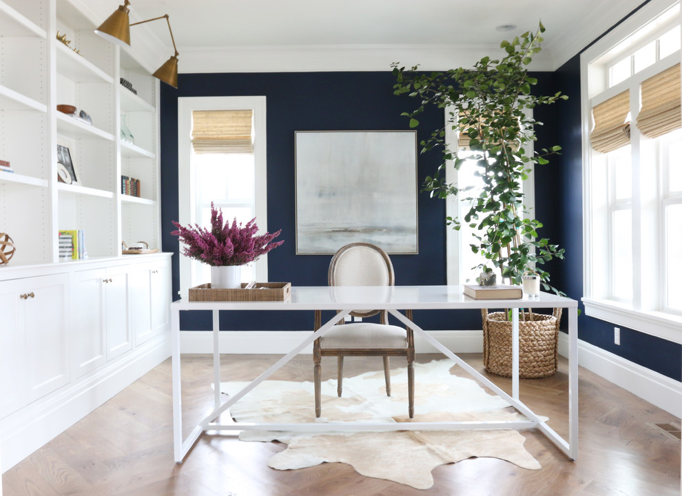 Foto de despacho costero con paredes azules, suelo de madera en tonos medios y escritorio independiente