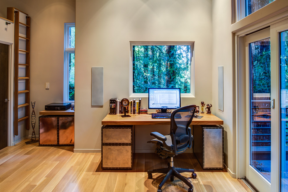 Foto di uno studio design con pareti beige e pavimento in legno massello medio