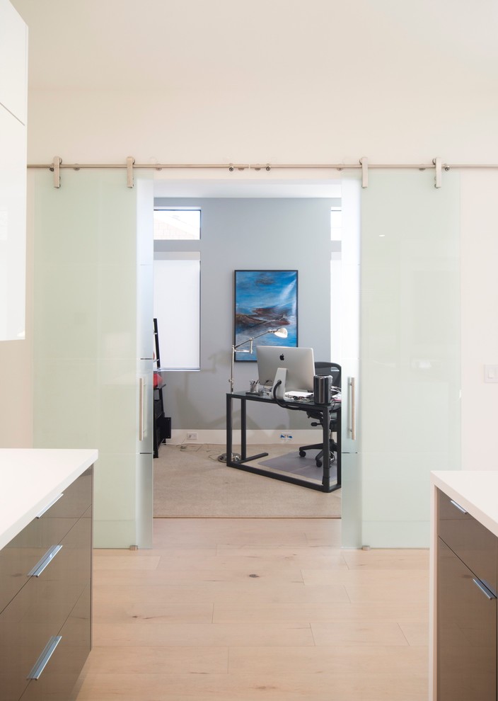 Großes Modernes Arbeitszimmer ohne Kamin mit Arbeitsplatz, grauer Wandfarbe, hellem Holzboden, freistehendem Schreibtisch und beigem Boden in San Francisco