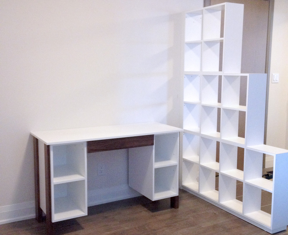 Diseño de despacho moderno pequeño sin chimenea con paredes blancas, suelo de madera en tonos medios y escritorio independiente