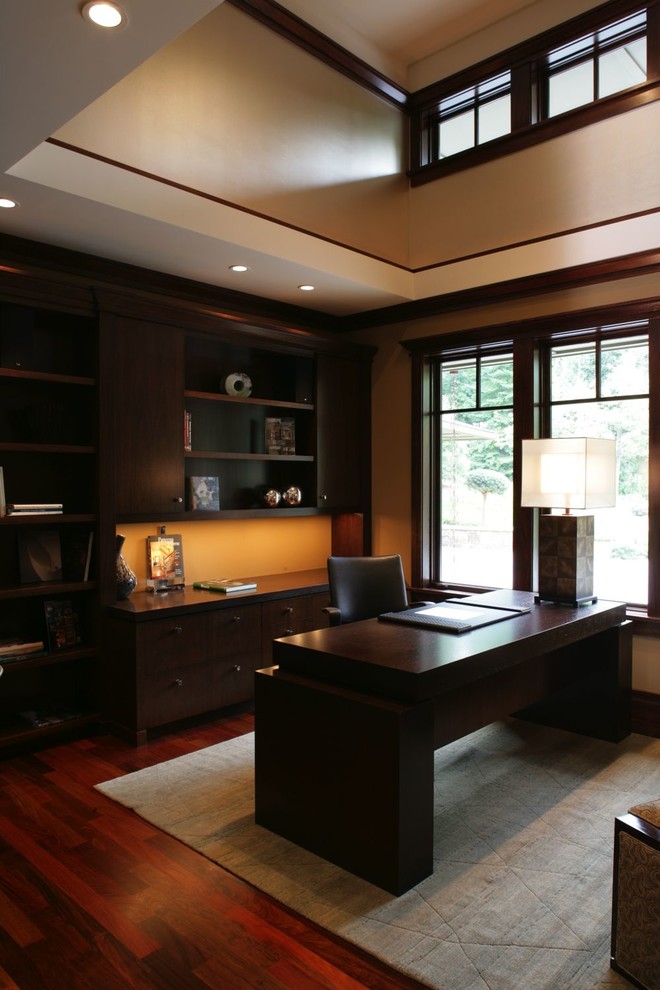 Großes Asiatisches Arbeitszimmer mit Arbeitsplatz, beiger Wandfarbe, dunklem Holzboden und freistehendem Schreibtisch in Minneapolis