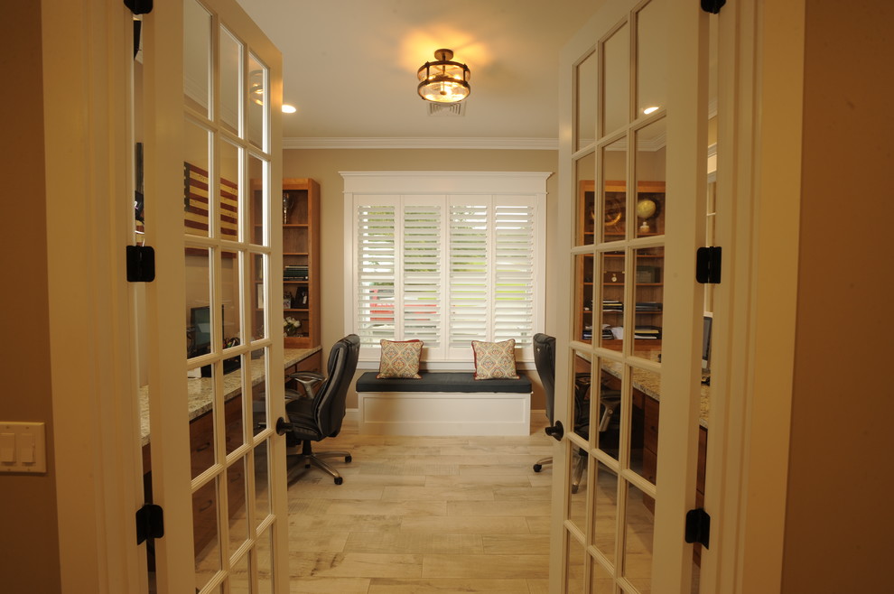 Foto di uno studio stile americano con pareti beige, pavimento con piastrelle in ceramica e scrivania incassata