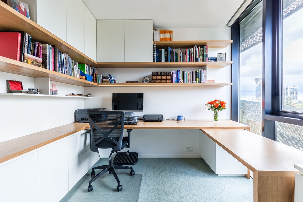 Inspiration för ett mellanstort funkis hemmabibliotek, med vita väggar, heltäckningsmatta och ett inbyggt skrivbord