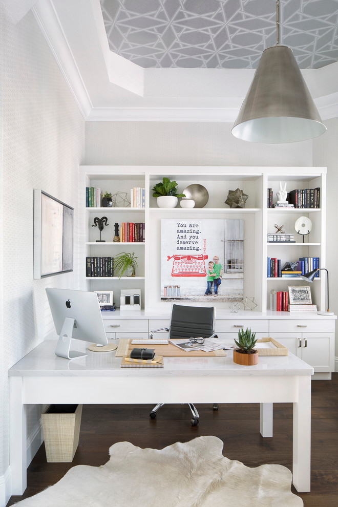 Foto de despacho clásico renovado con paredes blancas, suelo de madera oscura y escritorio independiente