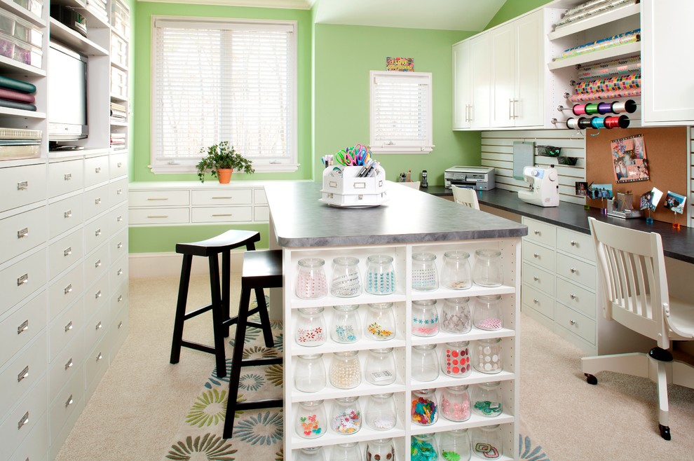 Inredning av ett klassiskt stort hobbyrum, med gröna väggar, heltäckningsmatta, ett inbyggt skrivbord och vitt golv