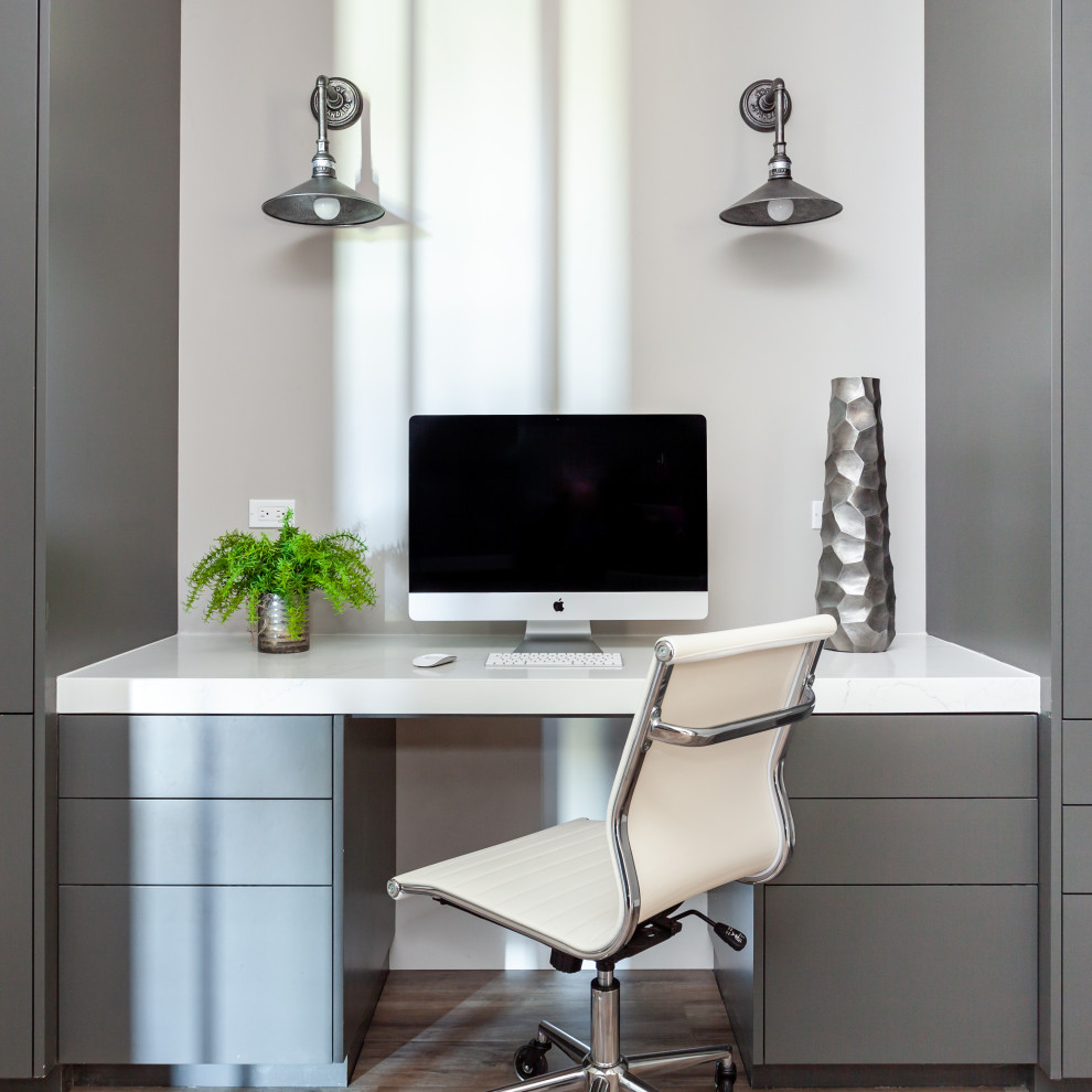 Imagen de despacho contemporáneo pequeño con paredes grises, suelo vinílico, escritorio empotrado y suelo marrón