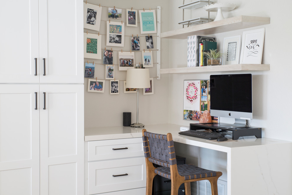 Immagine di un piccolo ufficio classico con pareti bianche, pavimento in laminato, nessun camino, scrivania incassata, pavimento marrone e soffitto a volta
