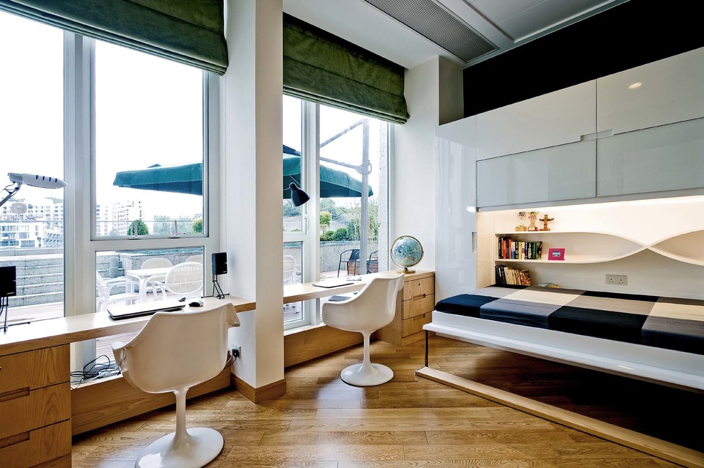 Foto de despacho contemporáneo con paredes blancas, suelo de madera en tonos medios y escritorio empotrado