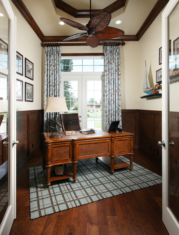 Modelo de despacho marinero de tamaño medio sin chimenea con paredes beige, suelo de madera en tonos medios y escritorio independiente