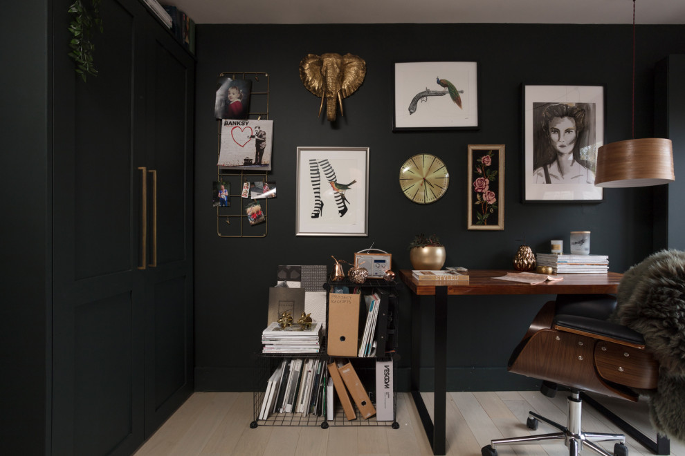 Ejemplo de estudio campestre de tamaño medio con paredes verdes, suelo de madera clara, escritorio independiente y suelo beige