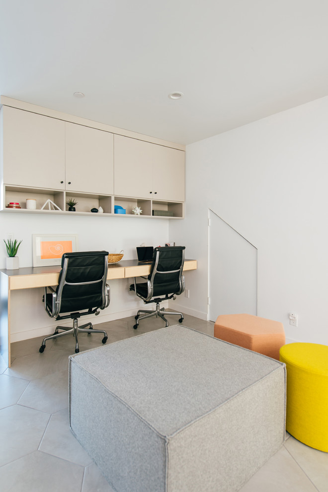 Kleines Arbeitszimmer mit weißer Wandfarbe, Porzellan-Bodenfliesen, grauem Boden, Einbau-Schreibtisch und Arbeitsplatz in Orange County