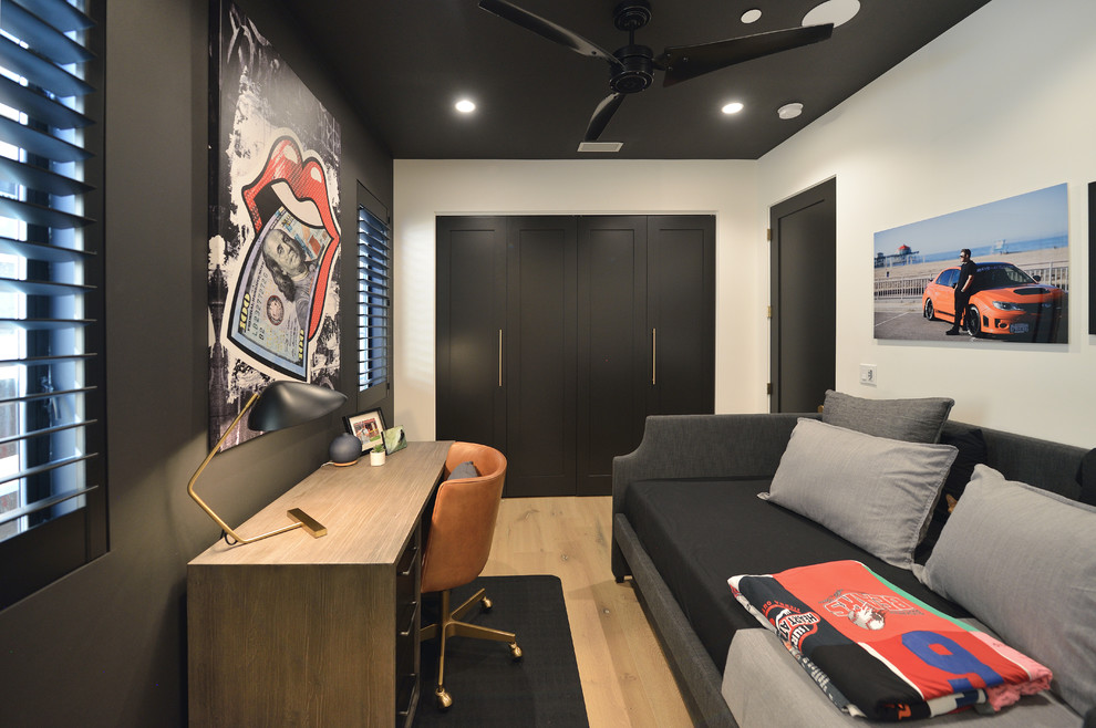 Ejemplo de despacho negro actual con paredes negras, suelo de madera clara, escritorio independiente y suelo beige