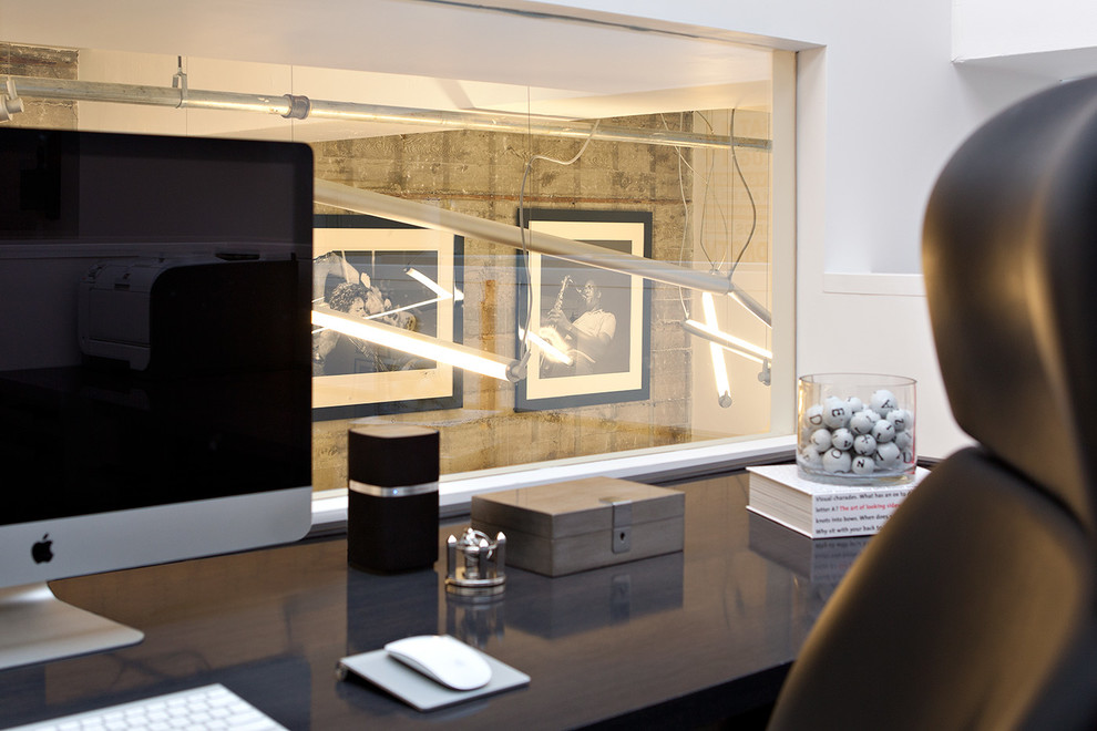 Aménagement d'un bureau moderne de taille moyenne avec un mur blanc, un bureau intégré, un sol en bois brun et un sol marron.