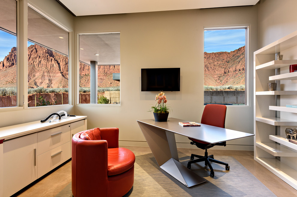 Imagen de despacho contemporáneo de tamaño medio sin chimenea con suelo de cemento, escritorio independiente, paredes beige y suelo gris