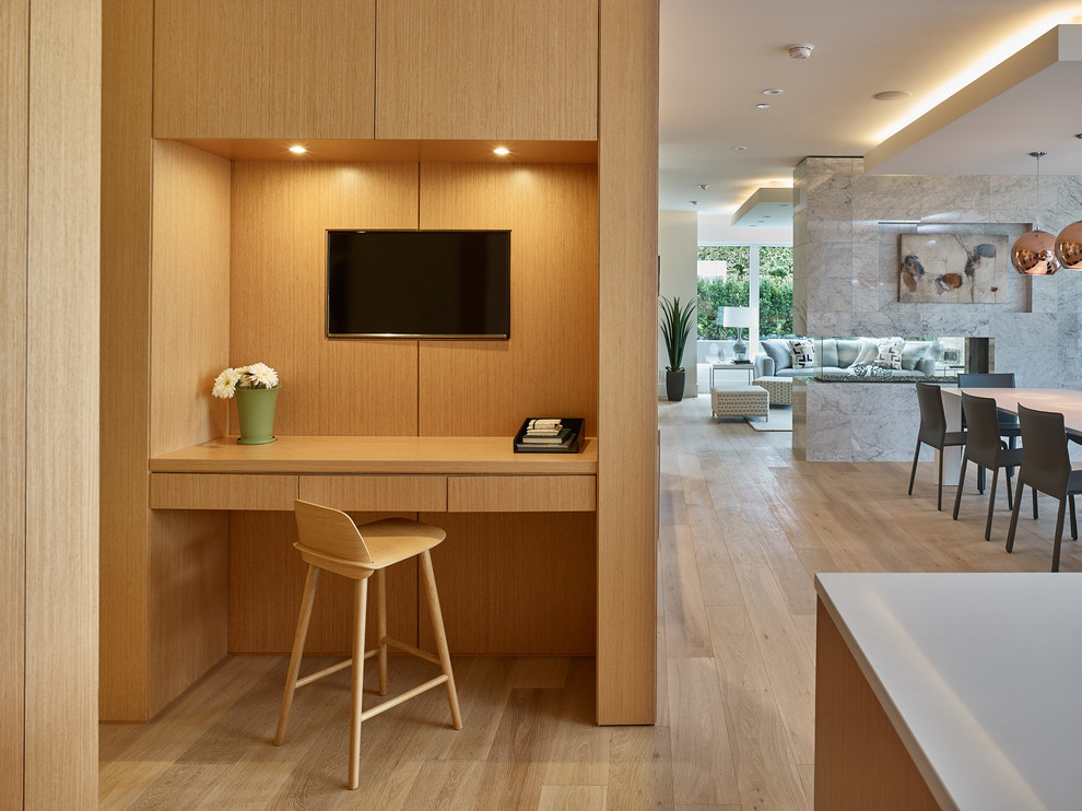 Kleines Modernes Arbeitszimmer mit weißer Wandfarbe, hellem Holzboden, Tunnelkamin, gefliester Kaminumrandung, Einbau-Schreibtisch und beigem Boden in Vancouver