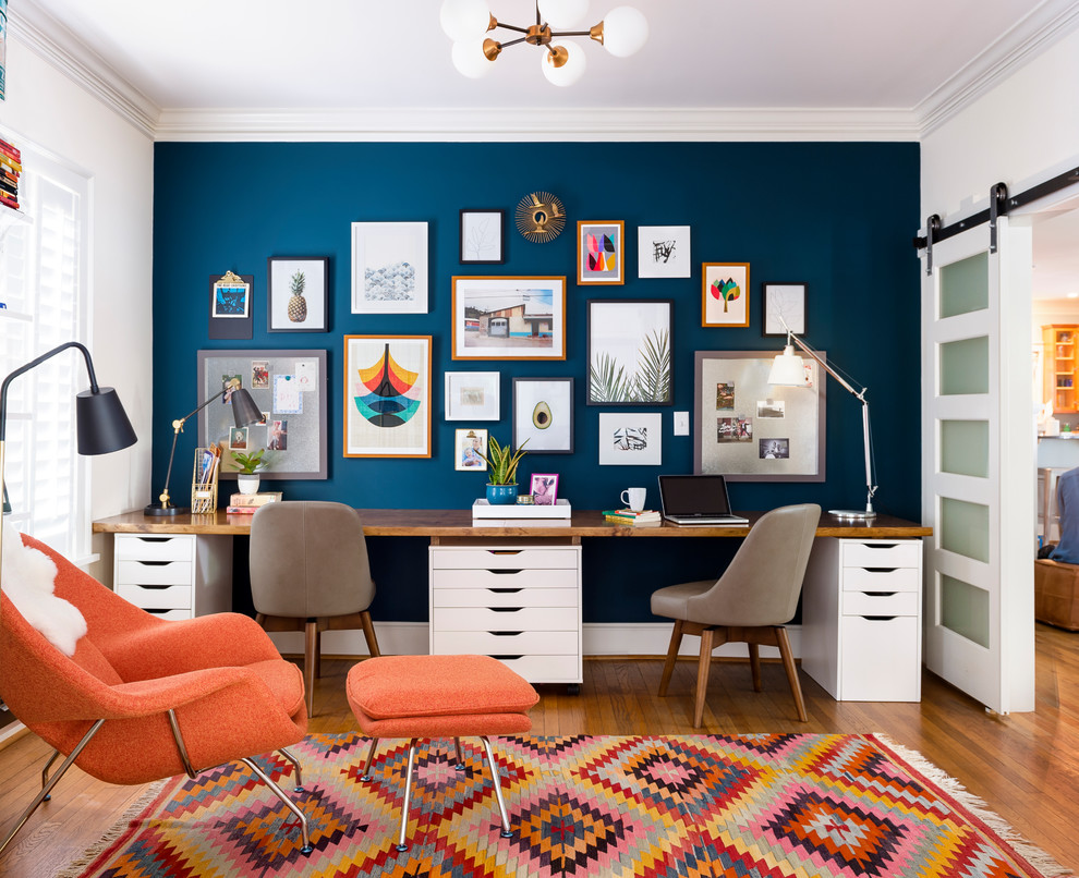 Foto de despacho ecléctico de tamaño medio con escritorio empotrado, paredes azules, suelo de madera en tonos medios y suelo marrón