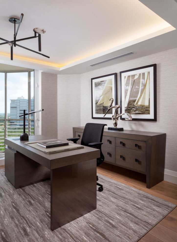 Mittelgroßes Maritimes Arbeitszimmer mit Arbeitsplatz, grauer Wandfarbe, braunem Holzboden, freistehendem Schreibtisch und braunem Boden in Miami