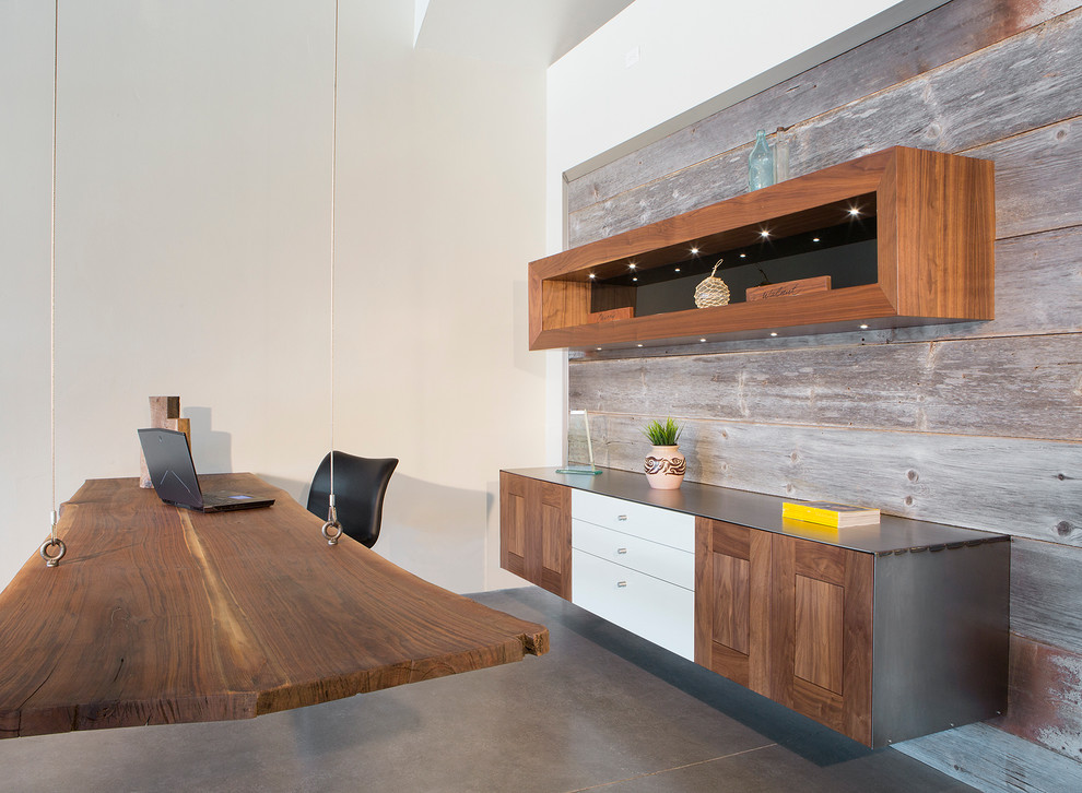 Großes Modernes Arbeitszimmer ohne Kamin mit weißer Wandfarbe, Betonboden, freistehendem Schreibtisch und braunem Boden in Phoenix