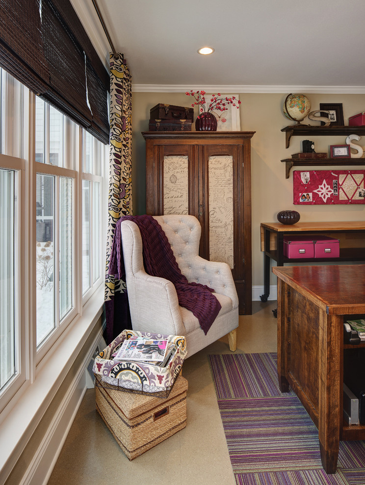 Modelo de despacho campestre de tamaño medio con paredes beige, suelo laminado y escritorio independiente