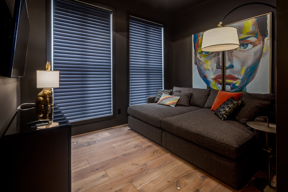 Ejemplo de despacho de estilo de casa de campo grande con paredes negras, suelo de madera clara y suelo beige