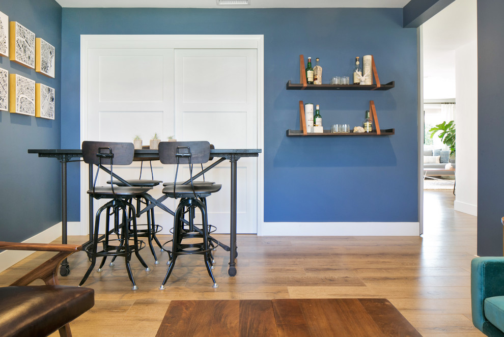 Diseño de estudio campestre de tamaño medio sin chimenea con paredes azules, suelo de madera en tonos medios y escritorio independiente