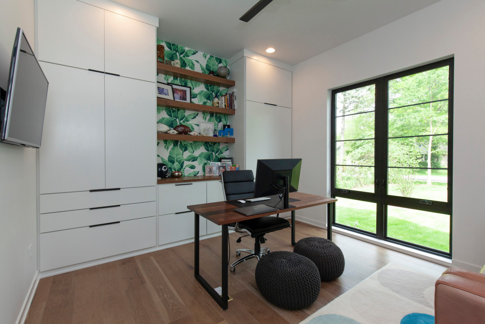 Ispirazione per un grande ufficio minimalista con pareti bianche, pavimento in legno massello medio, scrivania autoportante e pavimento marrone