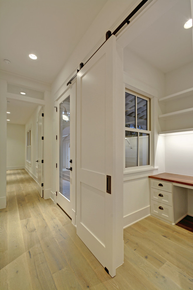 Idéer för mellanstora lantliga hemmabibliotek, med vita väggar, laminatgolv, ett inbyggt skrivbord och beiget golv