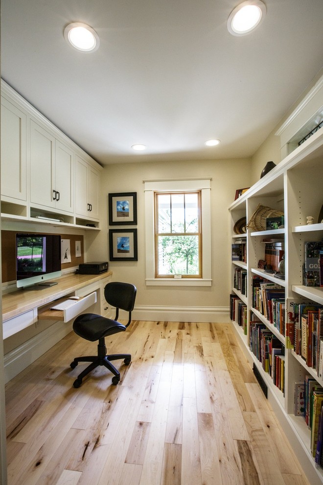 Foto de despacho de estilo de casa de campo con suelo de madera clara y escritorio empotrado