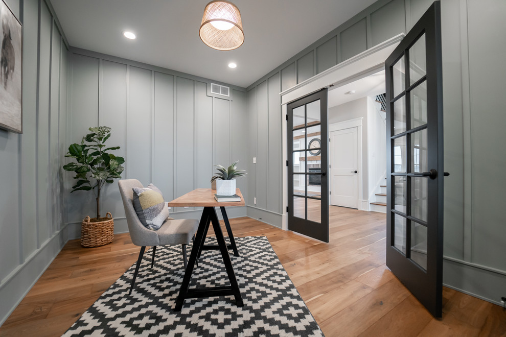 Imagen de despacho clásico renovado con paredes grises, suelo de madera en tonos medios, escritorio independiente y suelo marrón