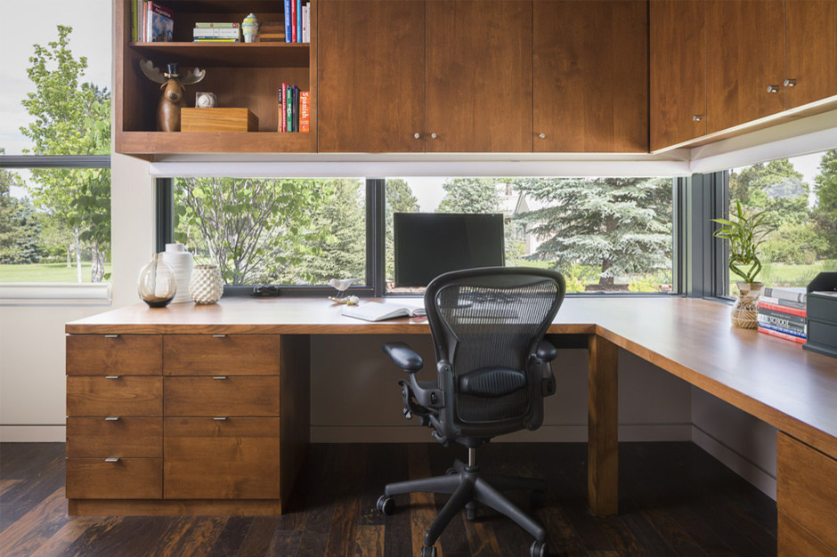 Ejemplo de despacho moderno de tamaño medio sin chimenea con paredes blancas, suelo de madera oscura, escritorio empotrado y suelo marrón
