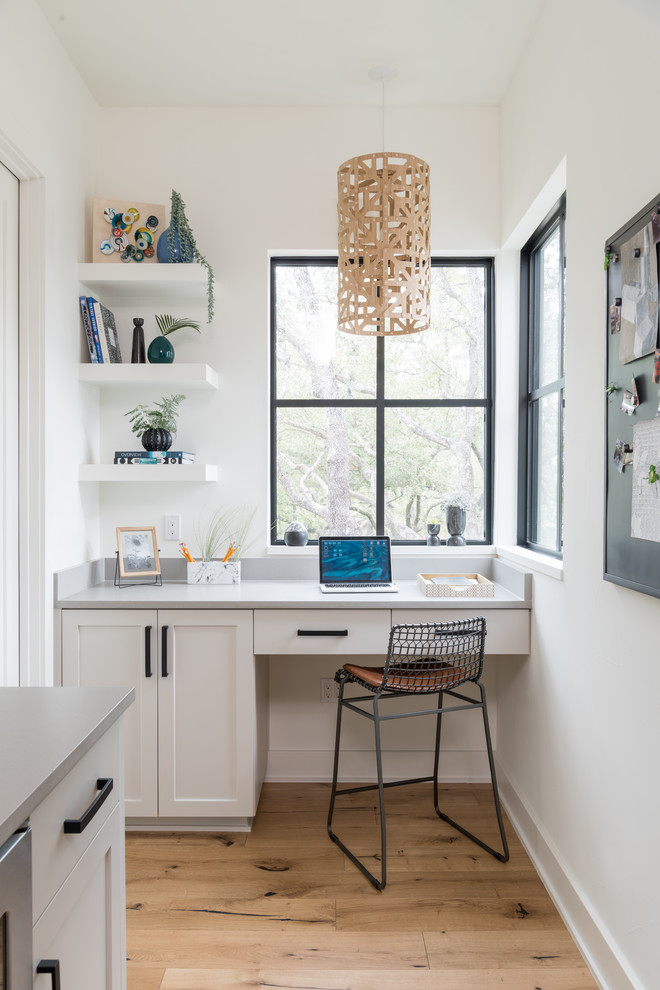 Landhaus Arbeitszimmer ohne Kamin mit Arbeitsplatz, gelber Wandfarbe, hellem Holzboden, Einbau-Schreibtisch und beigem Boden in Austin