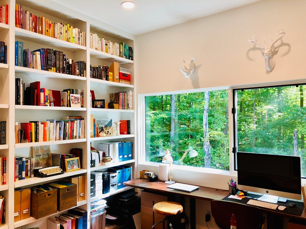 Inspiration for a contemporary freestanding desk home office library remodel in Raleigh with white walls