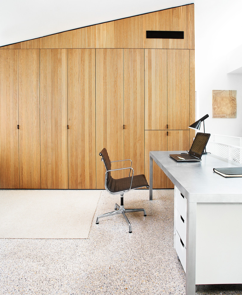 Immagine di uno studio minimalista con pareti bianche e scrivania autoportante