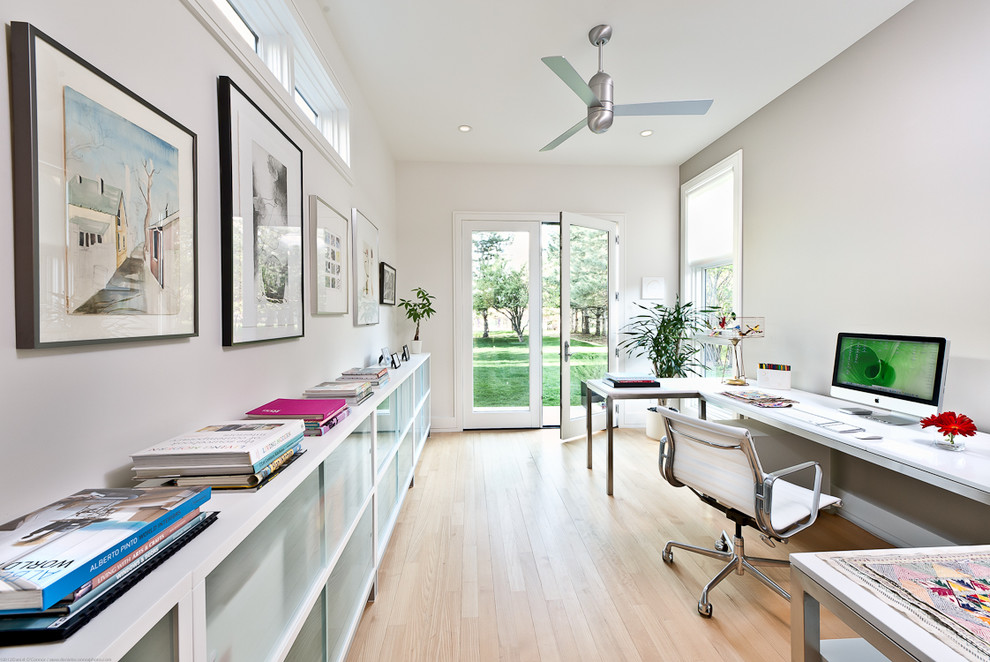 Cette image montre un grand bureau design avec un mur gris, parquet clair, un bureau indépendant et un sol beige.