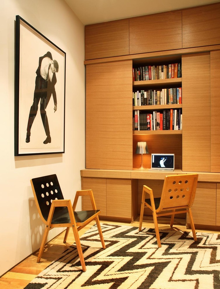 Ispirazione per uno studio minimalista con pareti bianche, pavimento in legno massello medio e scrivania incassata