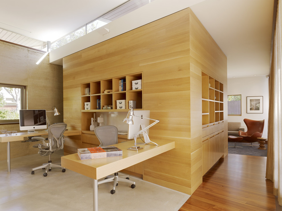 Réalisation d'un bureau minimaliste avec un sol en bois brun et un bureau intégré.