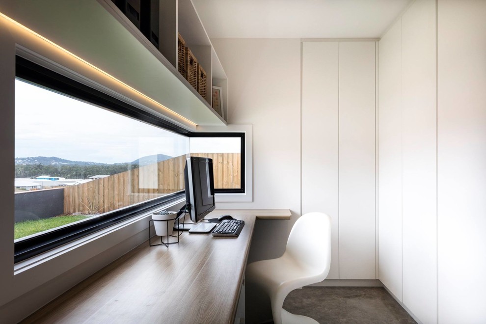 Kleines Modernes Arbeitszimmer mit Arbeitsplatz, weißer Wandfarbe, Teppichboden und Einbau-Schreibtisch in Sunshine Coast
