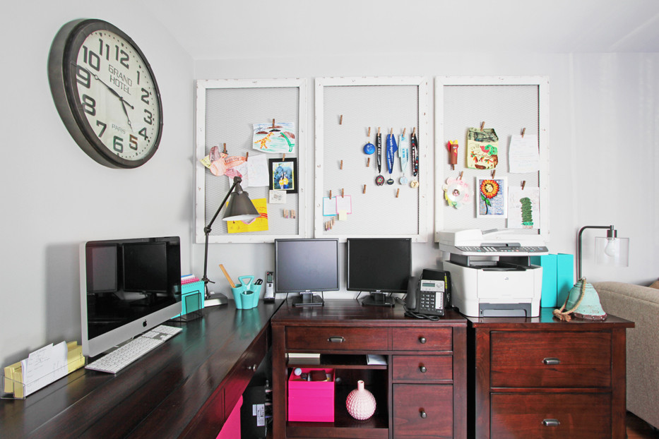 Foto på ett funkis arbetsrum, med grå väggar, ljust trägolv och ett fristående skrivbord