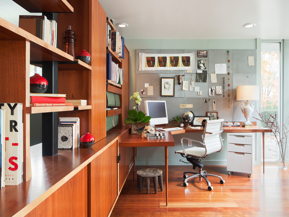 Home office - modern freestanding desk medium tone wood floor home office idea in Philadelphia with blue walls