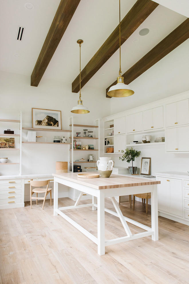 Inspiration for a large traditional home studio in Salt Lake City with white walls, light hardwood flooring, a built-in desk and beige floors.