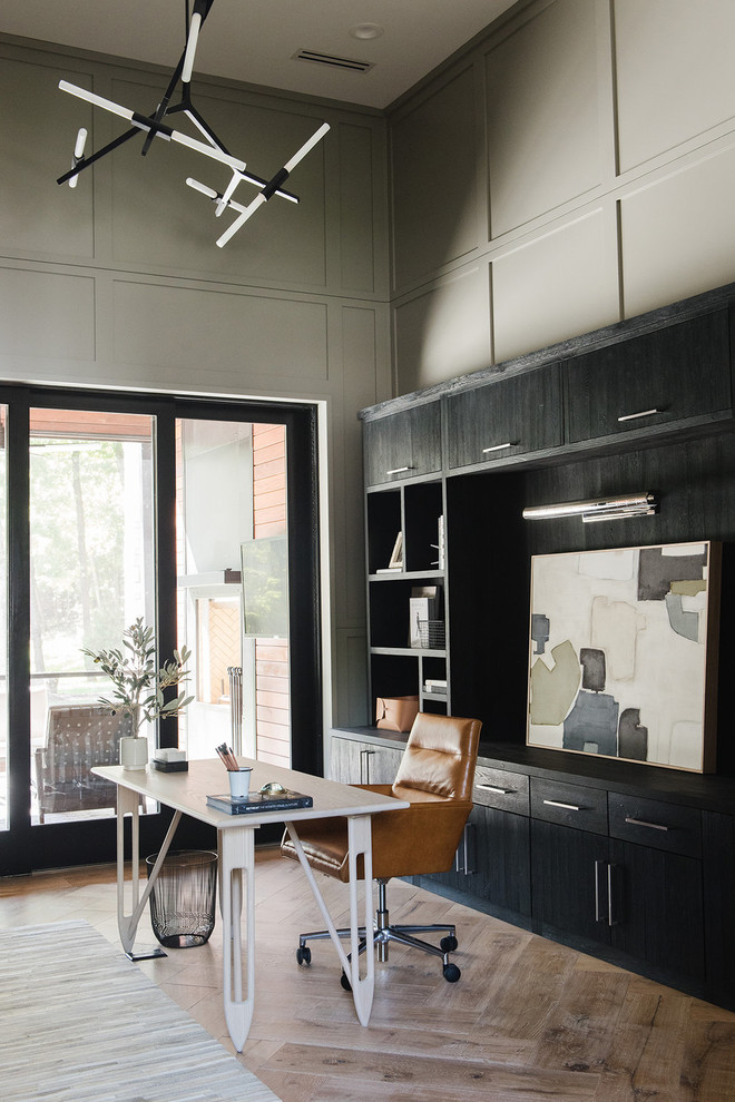 Imagen de despacho de estilo de casa de campo grande con paredes grises, suelo de madera clara y escritorio independiente