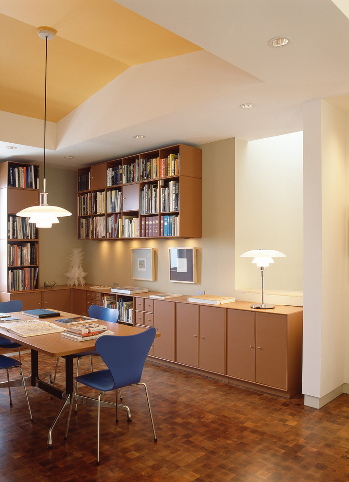 オースティンにあるコンテンポラリースタイルのおしゃれなホームオフィス・書斎 (白い壁、濃色無垢フローリング、自立型机、茶色い床) の写真
