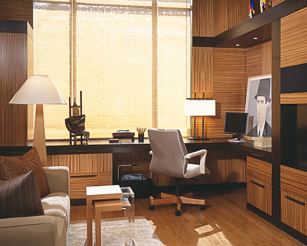 Imagen de despacho moderno grande sin chimenea con suelo de madera en tonos medios y escritorio empotrado